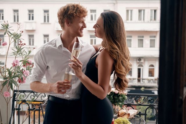 バルコニーでお酒を飲む男女